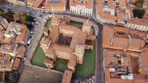 Aerial drone footage of the famous medieval castle in Ferrara old town in Italy. Shot with a downward rotation motion.  photo