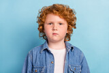 Photo of calm focused little ginger foxy boy look camera wear jeans jacket isolated blue color background