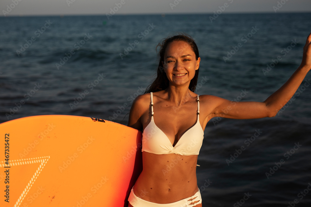 Young happy girl with surfboard. Hot sexy girl preparing for the surf. Beautiful woman enjoy in sunny day