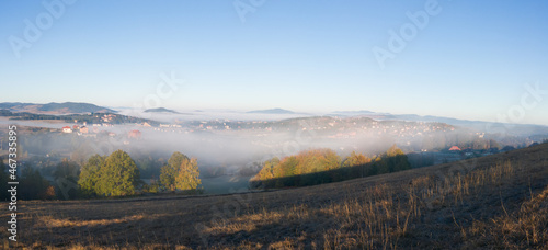 Panoramic view of the tourist town of Zlatibor in the fog on the mountain Zlatibor in Serbia surrounded by peaks breaking through the morning fog in October