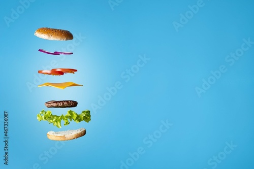 Beef burger split in mid air with space to write on the right of the picture