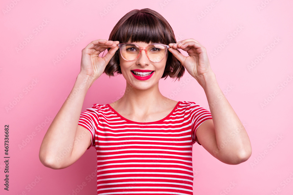 Photo portrait girl in spectacles striped t-shirt smiling cheerful isolated pastel pink color background Photo portrait girl in spectacles striped t-shirt smiling cheerful isolated pastel pink color background