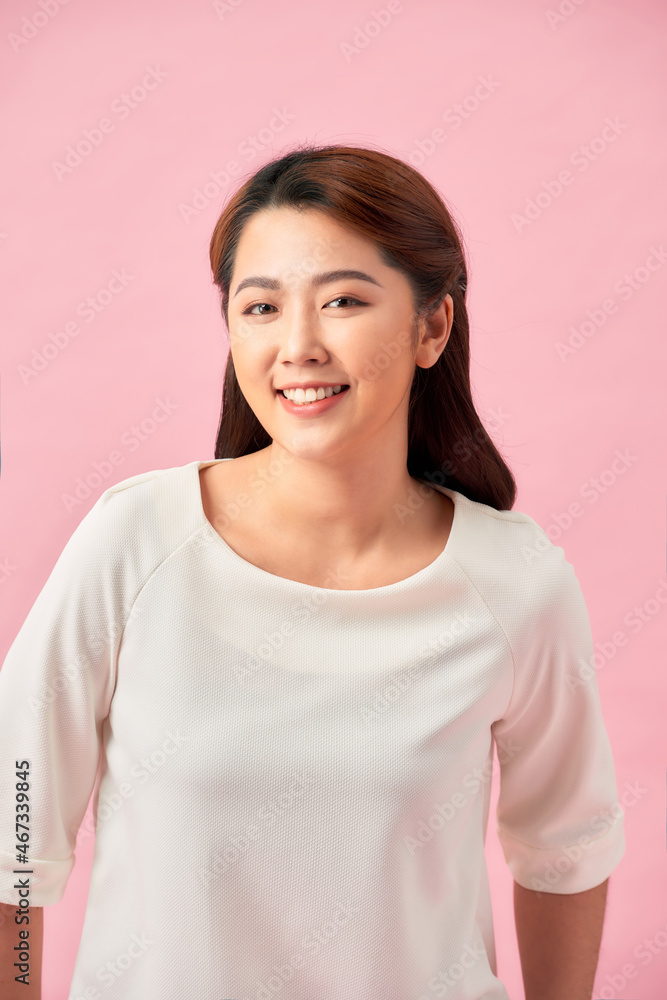 Casual young woman smiling - isolated over a pink background Casual young woman smiling - isolated over a pink background