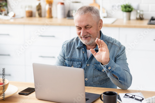 Senior caucasian man using laptop for video call sitting at home