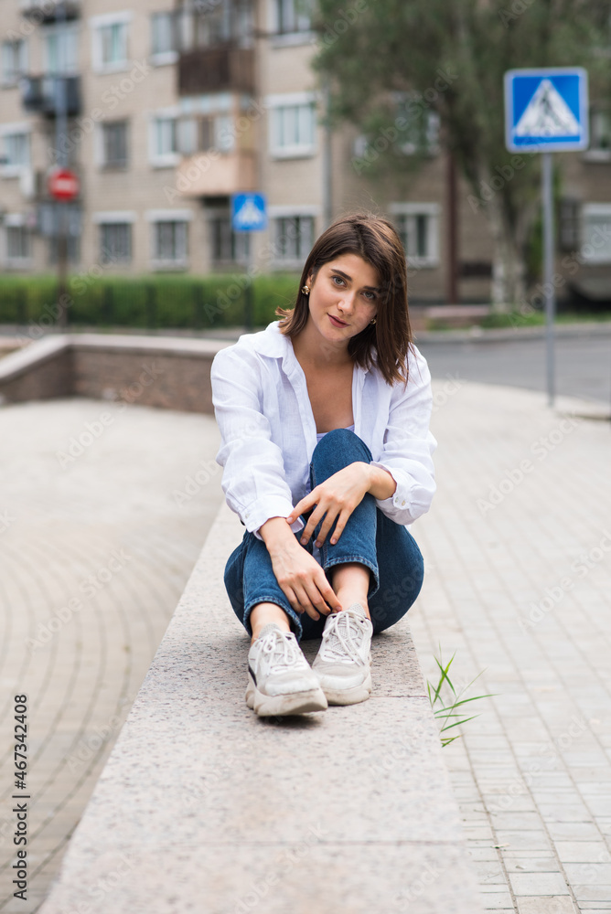 Attractive, happy and stylish brunette Caucasian girl posing on the street. Lifestyle and fashion concept. Attractive, happy and stylish brunette Caucasian girl posing on the street. Lifestyle and fashion concept.