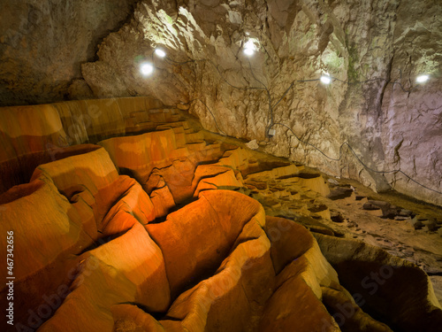 Фотография The interior of Stopica cave with tufa bathtubs illuminated with colored light,