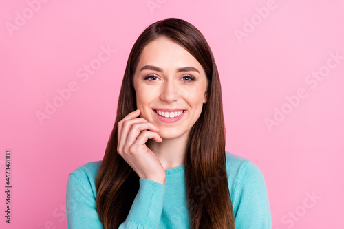 Portrait of attractive feminine cheerful girl touching cheek isolated over pink pastel color background © deagreez