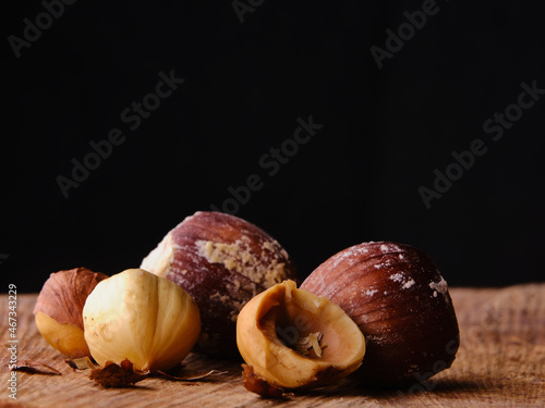 Raw hazelnuts on wood table with dark background