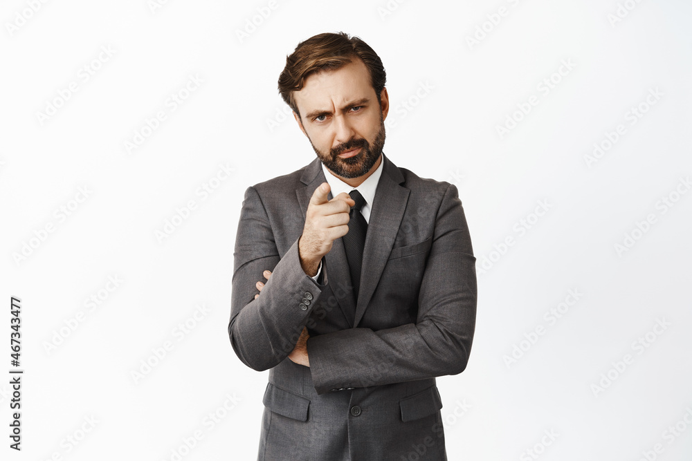 Disappointed male employer, businessman warn you, pointing finger at camera with disapproval, scolding employee, standing over white background Disappointed male employer, businessman warn you, pointing finger at camera with disapproval, scolding employee, standing over white background