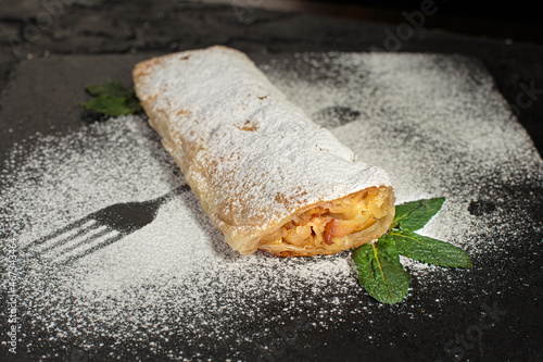 Traditional homamade artisanal apple or pumpkin pie served in a tray with powdered sugar on top to cover it. photo