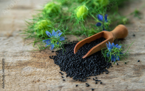 Black cumin seeds and flowers. Selective focus.