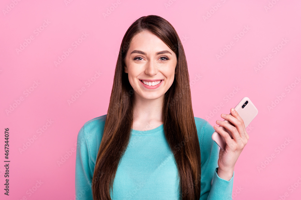 Fototapeta premium Portrait of attractive cheerful girl holding in hand device gadget 5g web isolated over pink pastel color background
