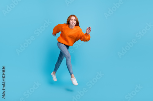Full length photo of young impressed lady run wear sweater jeans sneakers isolated on blue color background