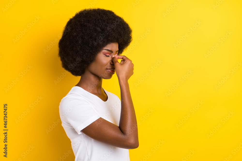 Photo of unhappy sad dark skin young woman hold fingers nose bad mood isolated on yellow color background Photo of unhappy sad dark skin young woman hold fingers nose bad mood isolated on yellow color background