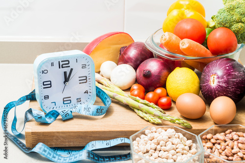 Still life with a clock, a tape measure and healthy food.