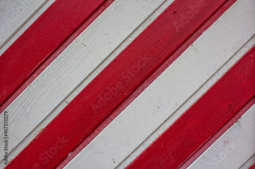 Board fence texture of white and red wooden boards arranged diagonally for web design. Wooden wall, red and white stripes. Seamless texture