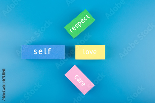 Mental health formula concept. Self respect, love and care written on multicolored rectangles on blue background