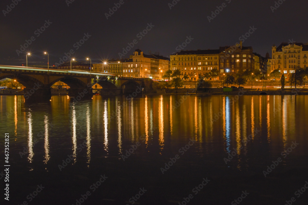 Night city with river, street lights are reflected in the water surface, beautiful landscape