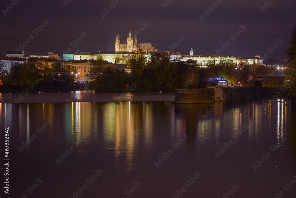 Prague Castle at night, street lights reflected in the water surface, beautiful night city