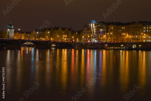 Night city with river, street lights are reflected in the water surface
