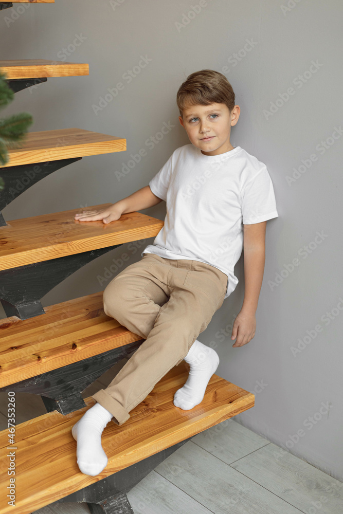 Minimalistic studio photo of eight old caucasian boy wearing in white t-shirt and beige pants for creating mockups for presentation graphic tees and pattern design Minimalistic studio photo of eight old caucasian boy wearing in white t-shirt and beige pants for creating mockups for presentation graphic tees and pattern design