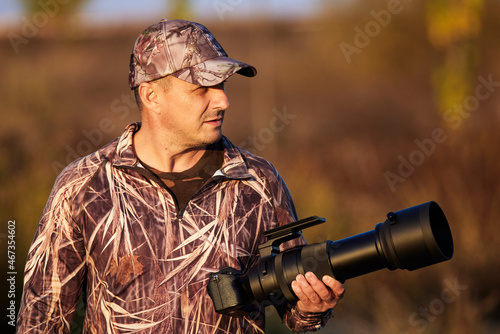 a professional willife photographer in camouflage outfit photo
