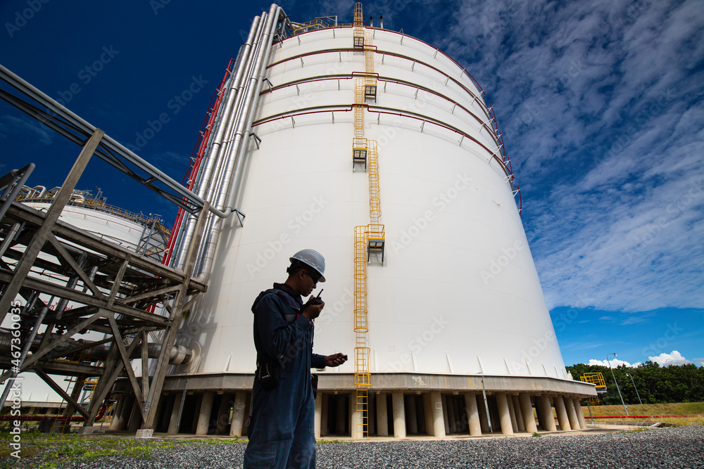 Obraz premium Male workers works permit industry visual inspection of the big white tanks for gas propane