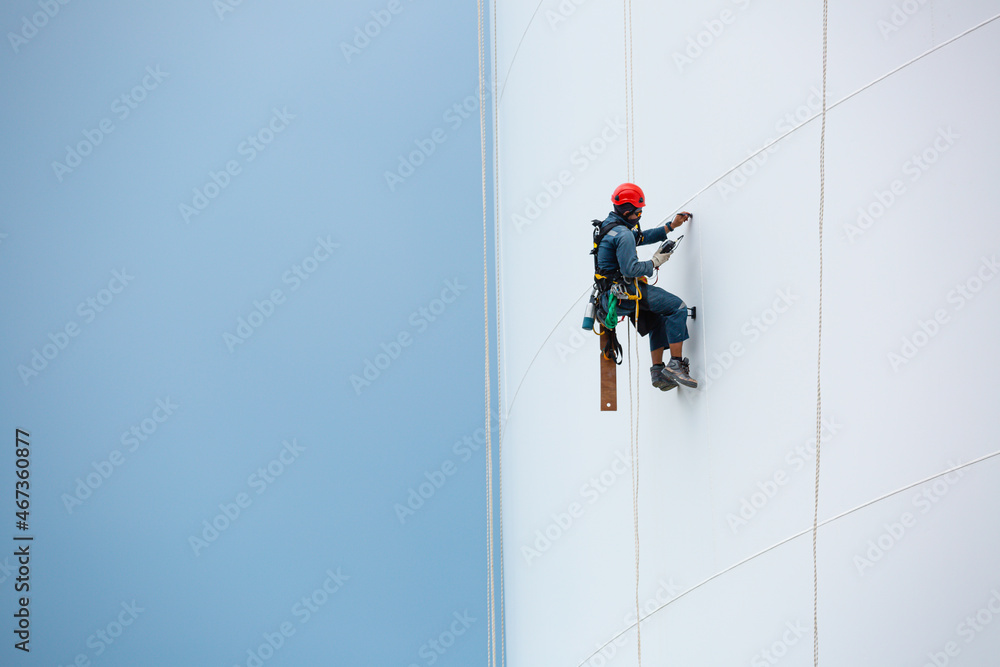 Male workers down height tank rope access inspection of thickness shell plate storage tank gas