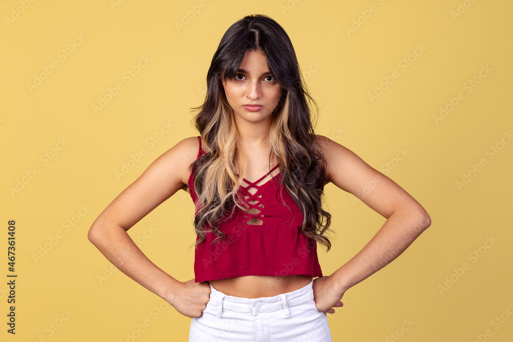 Studio shot of young annoyed girl, student in casual summer style clothes isolated on yellow studio backgroud. Studio shot of young annoyed girl, student in casual summer style clothes isolated on yellow studio backgroud.