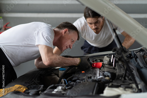 Mechanic changing engine, service car workshop automobile. professional man shop maintenance