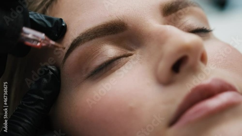 Cosmetologist finishing permanent eyebrows makeup. Closeup view of beautiful result of microblading tattoo