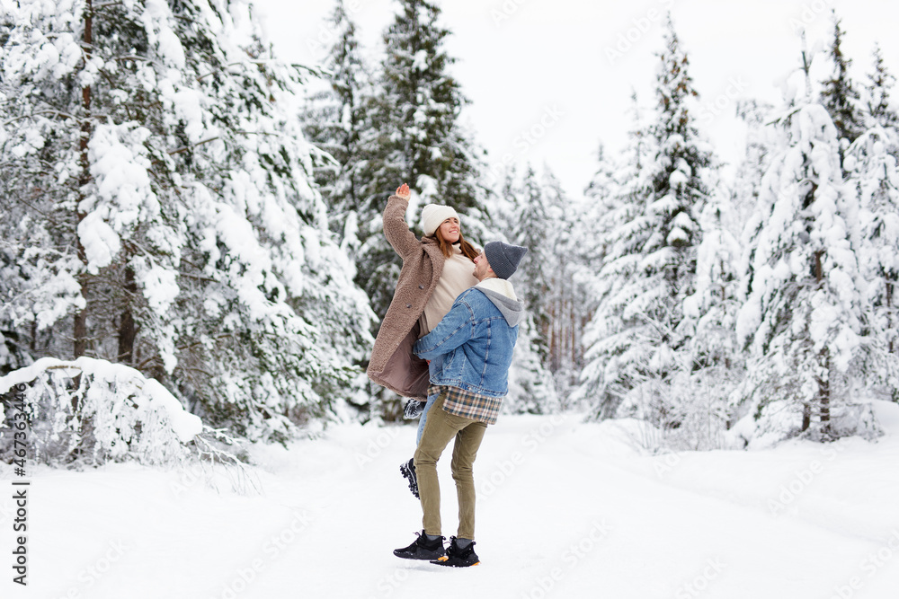 man and woman walking and making fun in winter forest