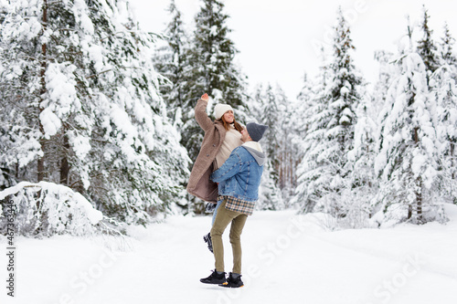 man and woman walking and making fun in winter forest