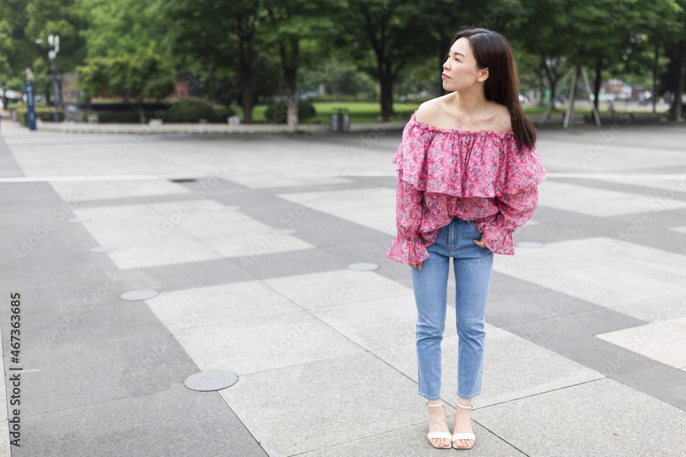 Portrait of young asian woman wearing stylish casual clothing and walking outdoor in city. Happy stylish woman with smiley face enjoys life Portrait of young asian woman wearing stylish casual clothing and walking outdoor in city. Happy stylish woman with smiley face enjoys life