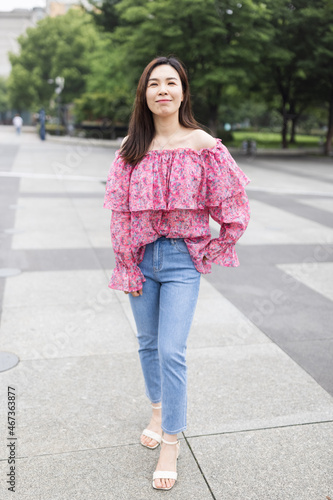 Portrait of young asian woman wearing stylish casual clothing and walking outdoor in city. Happy stylish woman with smiley face enjoys life © Алина Бузунова