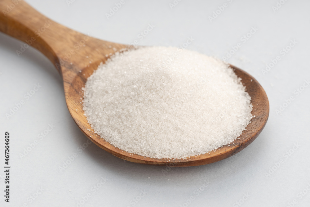 Sugar In Wooden Spoon on gray background Sugar In Wooden Spoon on gray background