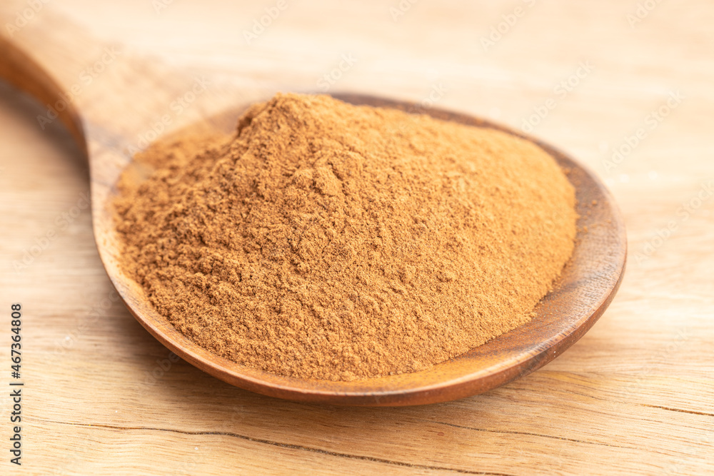 Cinnamon powder in wooden spoon on wooden table. Close up Cinnamon powder in wooden spoon on wooden table. Close up