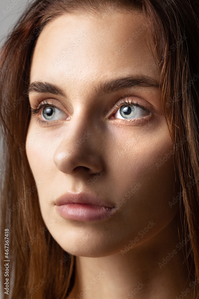 Close-up face of young beautiful girl without makeup isolated over gray studio background. Natural beauty concept. Close-up face of young beautiful girl without makeup isolated over gray studio background. Natural beauty concept.