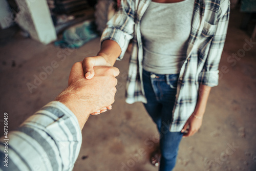 Close up mixed race couple hand shaking after long day of work