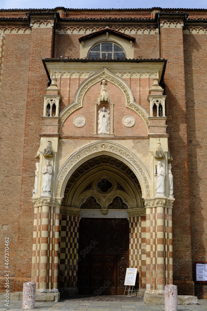 Gothic door. Access door to the gothic cathedral of Asti.Portal with marble columns and red terracotta bricks and white marble sculptures. 