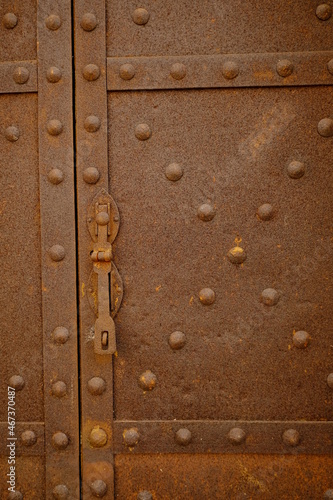 Old lock. Iron door with studs and lock.Rusted iron sheet of an ancient door. 