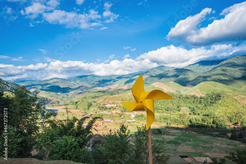 Small Yellow Wind turbine on the mountain with landscape view of Sapan village nan thailand.Sapan is a small, quiet village, surrounded by trees, fields, and beautiful landscapes