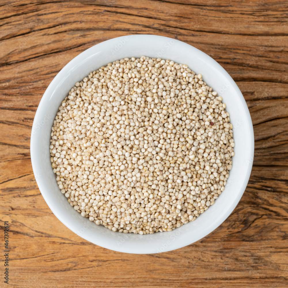 Raw quinoa grains in a bowl over wooden table Raw quinoa grains in a bowl over wooden table