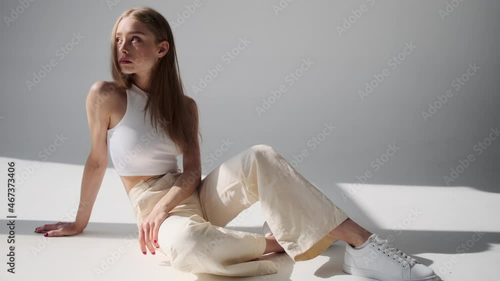 Sensual woman posing while sitting on floor over white background Stock ...
