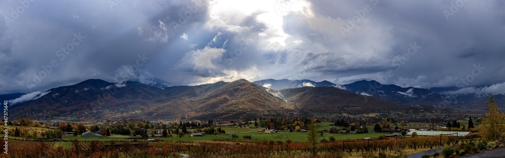 Giant panorama looking acorss a vineyard at the valley of Ashland Oregon with dramatic clouds and lighting
