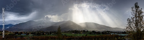 Dark storm clouds give way to bright sunlight streaming into the valley of Ashland Oregon