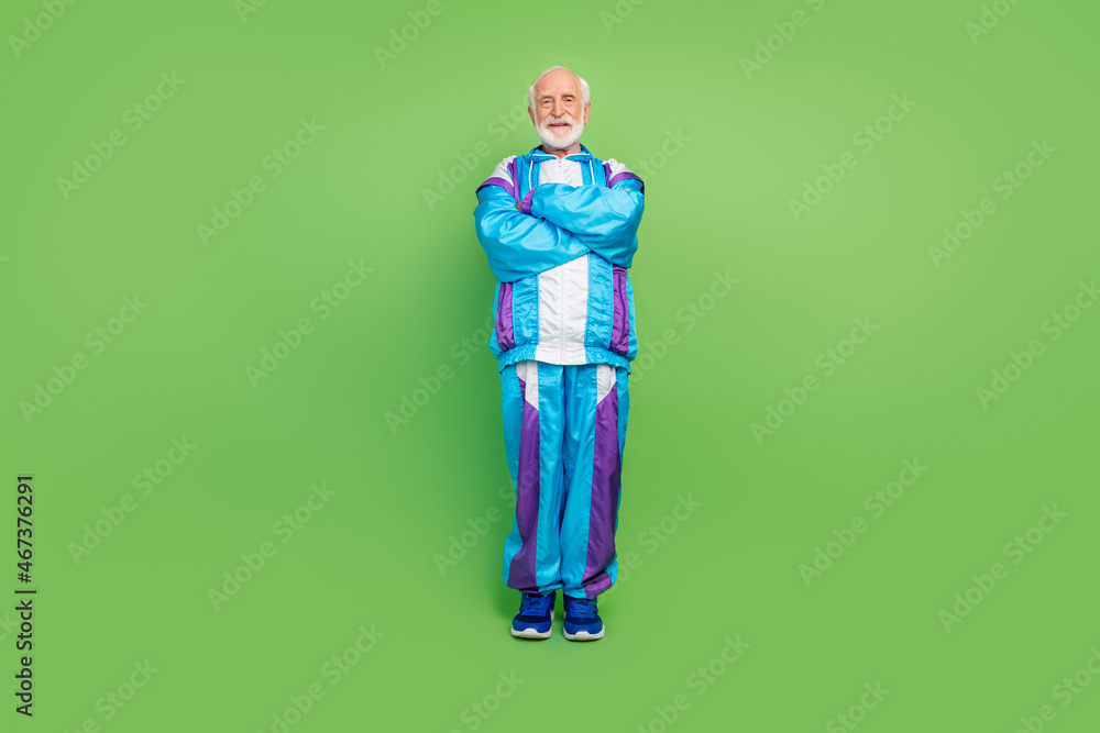 Photo of cool pretty mature guy dressed blue sport suit smiling walking arms crossed isolated green color background