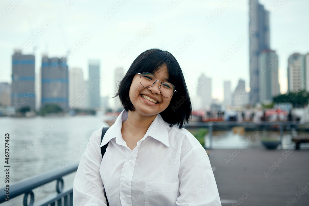 Fototapeta premium asian teenager toothy smiling with happiness face ,standing at city outdoor