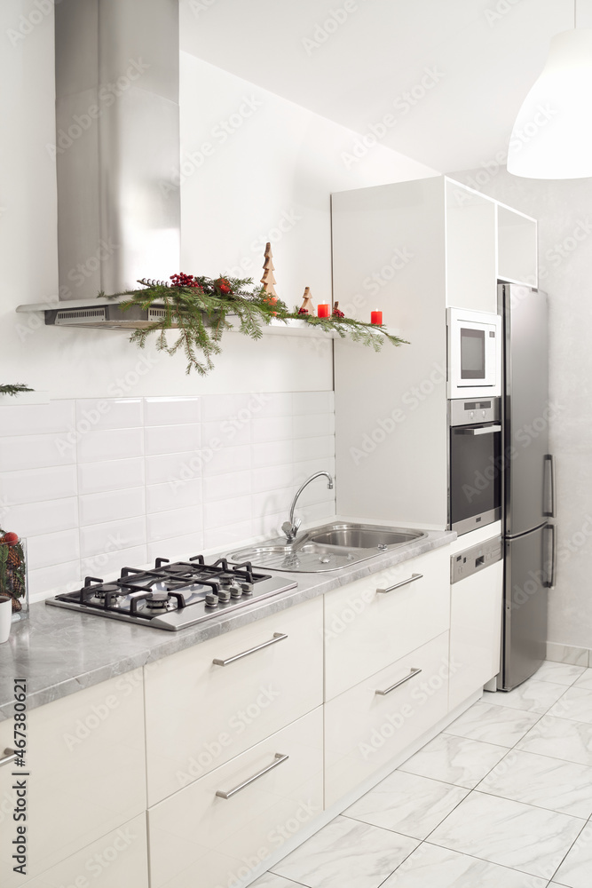 Fototapeta premium Modern white clean kitchen with Christmas decoration. Concept of interior of beautiful apartment.