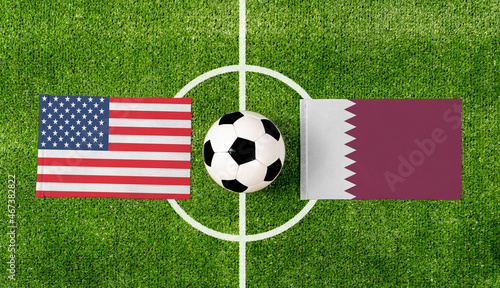 Top view soccer ball with USA vs. Qatar flags match on green football field.